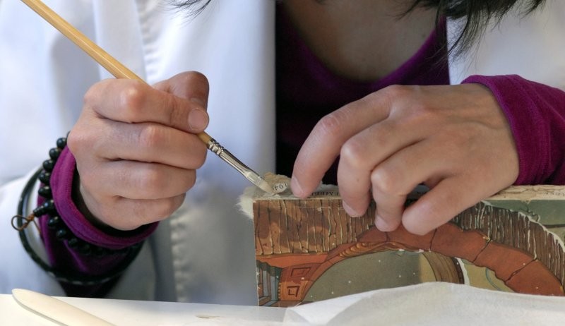 Consolidació dels estrips i reforç estructural del llom d’una revista.